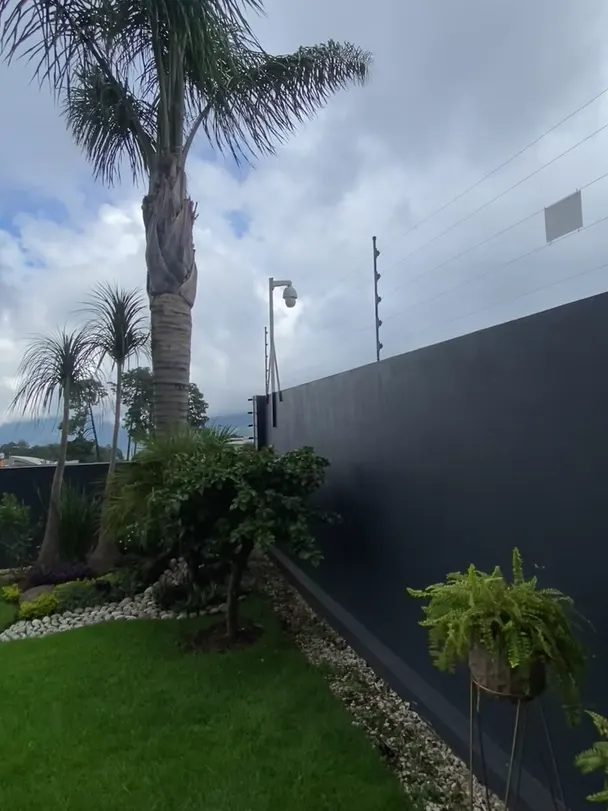 Residencia con cámara PTZ y cerca eléctrica sobre la barda
